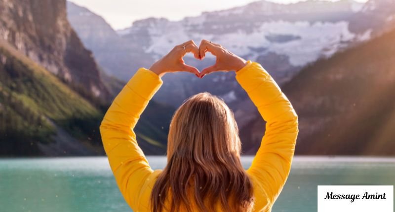 Woman in yellow jacket making heart shape symbolizing Yellow Heart Emoji Meaning