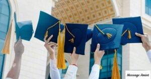 Graduates raising their blue graduation caps with gold tassels in celebration.
