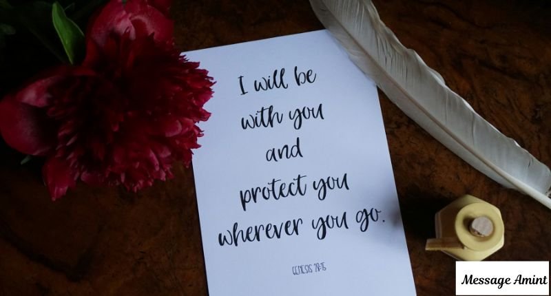 A handwritten blessing card placed on a wooden table next to a red flower and a quill feather, perfect for wedding and anniversary messages for a sister-in-law.